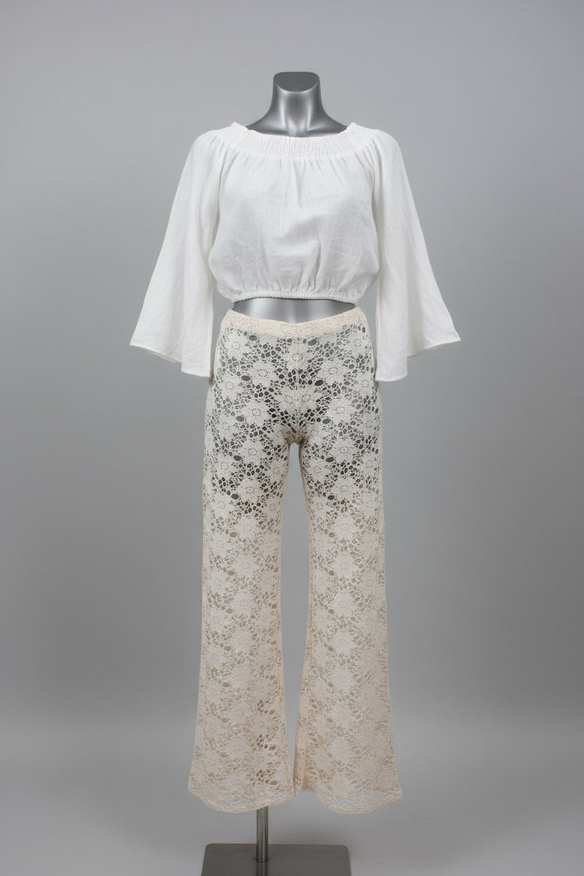 A two-piece women's outfit displayed on a mannequin against a gray studio background. The set includes a white off-the-shoulder short-sleeve crop top and off-white lace wide-leg pants with black floral embroidery.