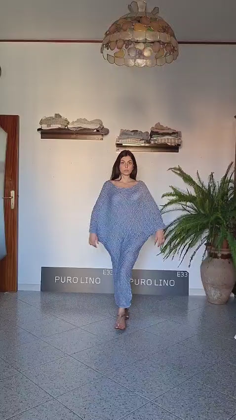 A woman modeling a loose, flowy blue knit italian linen  tunic dress in a boutique 