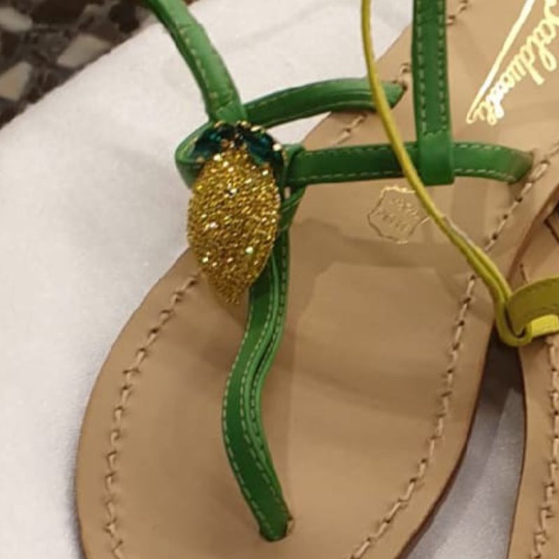  pair of green leather sandals with yellow Swarovski jewels and blue soft plantar, hand stitched and displayed on a flat surface.